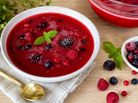 Fruchtige Beeren-Kaltschale mit gemischten Beeren in einer Glasschale, garniert mit frischen Beeren und Minze.