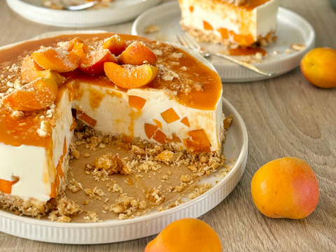 Veganer No-Bake-Aprikosen-Käsekuchen mit frischen Aprikosen auf knusprigem Keksboden.